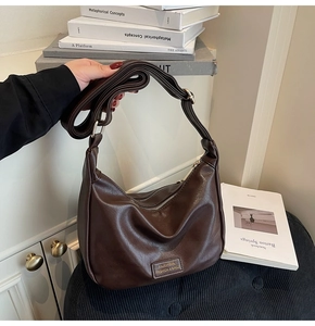 Detail of soft dark coffee hobo bag featuring litchi grain and adjustable strap