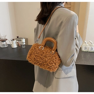 Detail of caramel faux fur crossbody bag with leather straps on a grey suit model