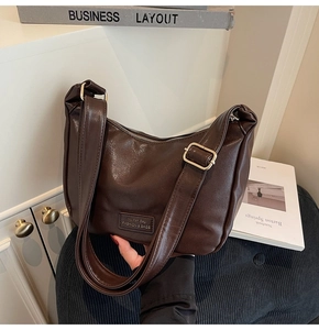 Detail view of coffee brown crescent bag with smooth oil finish and adjustable strap
