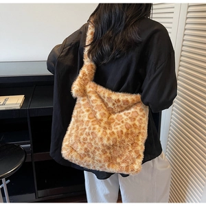 Rear view of model wearing a large leopard print faux fur tote bag in a modern interior