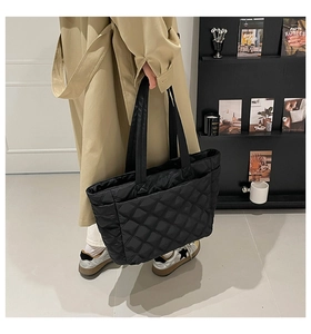 Detailed close-up of black quilted tote bag with diamond pattern and large capacity