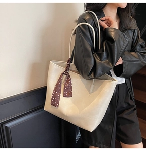 White large capacity leather tote bag with decorative polka dot scarf on a model