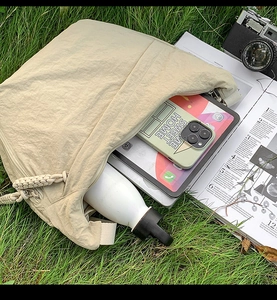 Interior view of beige textured tote bag showing high capacity for tablet and water bottle