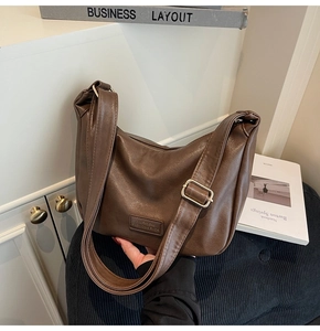 Detail view of dark brown hobo bag with adjustable strap and metal buckle closure