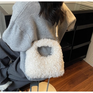 Detailed macro view of white faux fur texture and handle on a plush winter handbag
