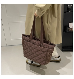 Detail of brown quilted tote bag showing rhombus stitching and side pocket design