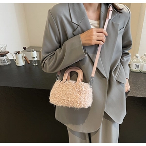 Close-up of pink faux lamb wool handbag with leather handle and metallic hardware