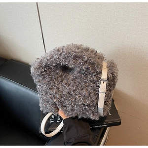 Detail of grey plush faux fur texture and white leather adjustable strap with silver buckle