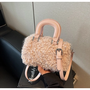 Detail of pink faux fur crossbody bag with smooth round handles and silver metal hardware