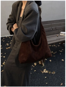 Braune Wildleder-Tote-Bag in herbstlicher Straßenszene mit grauem Blazer und Blättern