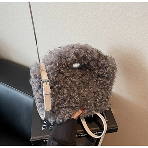 Detail of grey fluffy plush handbag featuring adjustable leather strap and silver metal buckle
