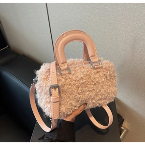 Detailed close-up of pink faux lamb wool bucket bag with leather handles and silver hardware
