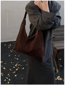 Nahaufnahme der braunen Vintage-Wildleder-Hobo-Tasche kombiniert mit grauem Anzug