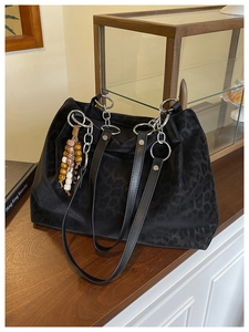 Detail of black leopard tote with silver chain and decorative multi-color wooden beads