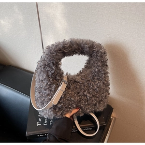Detail of grey faux shearling handbag with adjustable leather strap and silver metal buckle