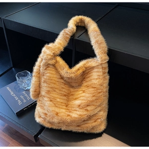 Close-up of soft faux fur texture on a warm orange tiger striped hobo shoulder bag