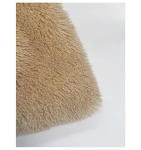 Close-up of soft beige plush fabric showing fluffy curly texture on the tote bag
