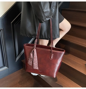 Detail of burgundy tote bag in matte PU leather with decorative polka dot silk scarf
