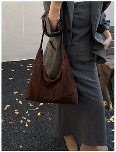 Detailansicht der braunen Wildleder-Hobo-Tasche Textur und Schultergurt am Modell