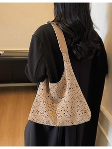 Laser-cut beige cutout tote bag with geometric floral patterns shown on model's shoulder