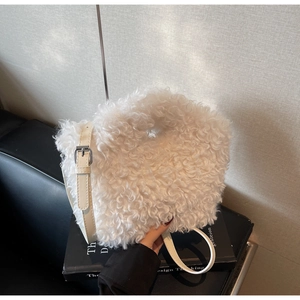 Close-up of white fluffy plush shoulder bag featuring adjustable beige leather strap