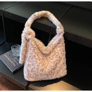 Detail of the soft faux fur texture and knotted strap on a leopard print hobo bag