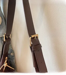 Close-up of adjustable dark brown leather strap with polished gold buckle and fine stitching