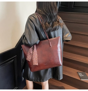 Detail view of reddish-brown PU leather tote bag with stylish polka dot scarf accessory
