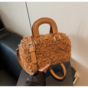 Detailed macro view of the fluffy brown fleece texture and premium leather handle of the bucket bag