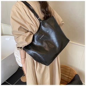 Side view of large black oil-wax leather tote bag on model for commuter styling