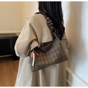Detail of vintage brown frosted tote featuring quilted texture and large wooden bead strap