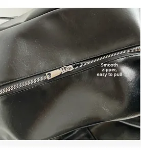 Macro shot of high-quality smooth silver metal zipper on black textured leather tote bag