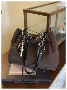 Close-up of leopard print tote bag with metallic silver rings and beaded charm accessory