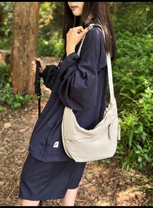 Detail of beige crescent shoulder bag made of textured nylon for outdoor hiking use