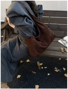Detailansicht einer großen braunen Wildleder-Hobo-Tasche im herbstlichen Stil