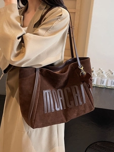 Brown suede tote bag with MOACHI lettering and bear charm shown on model