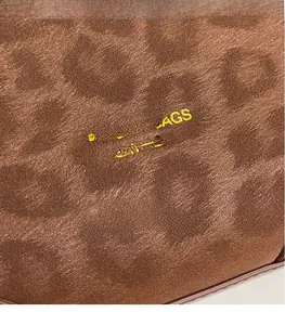 Detail of brown leopard print texture with fashion and bags leather text branding