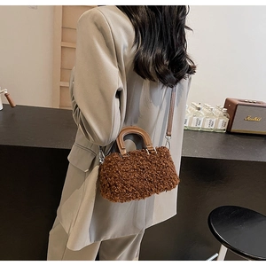 Detailed shot of brown faux shearling mini bag with leather handles and silver hardware
