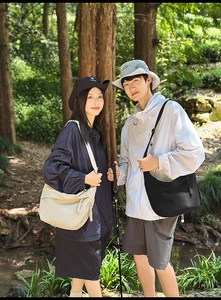 Detail of a minimalist half-moon crossbody bag with water-resistant fabric in nature