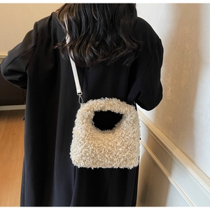 Detail of plush faux shearling handbag paired with a black winter coat and strap