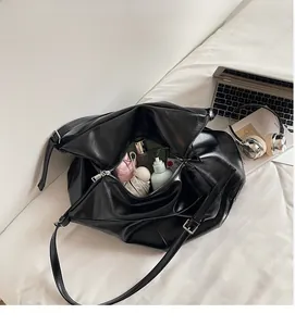 Top view of large black tote bag showing spacious interior with cosmetics and laptop