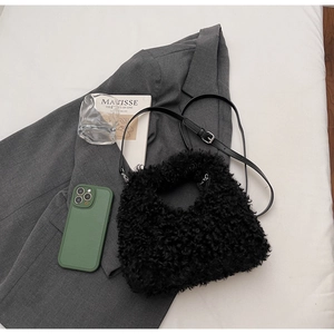 Close-up of black faux fur texture and adjustable leather strap on a shoulder bag
