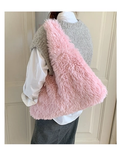 Rear view of model wearing a soft pink plush tote bag with fluffy texture and wide strap