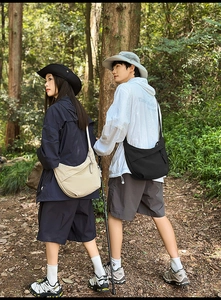 Close-up of minimalist nylon crescent bags in black and beige for outdoor hiking and travel