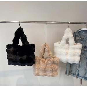 Gros plan de sacs cabas en fausse fourrure peluche noire, beige et blanche à texture douce