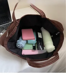 Intérieur spacieux du cabas à carreaux marron montrant le rangement pour tablette et objets