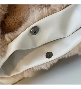 Détail de deux fermoirs magnétiques sur un sac cabas en peluche marron et simili cuir