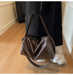 Close-up of the vintage dark brown leather tote showing fine texture and wide shoulder strap