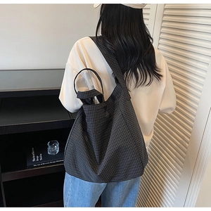 Detail of checkered canvas tote bag with wide shoulder strap and spacious interior