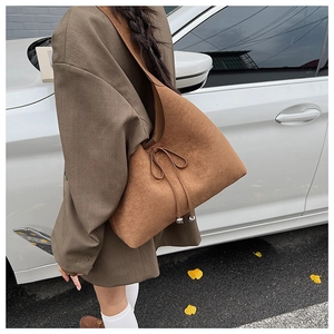 Brown faux suede hobo bag with drawstring bow and silver metal beads detail in street style